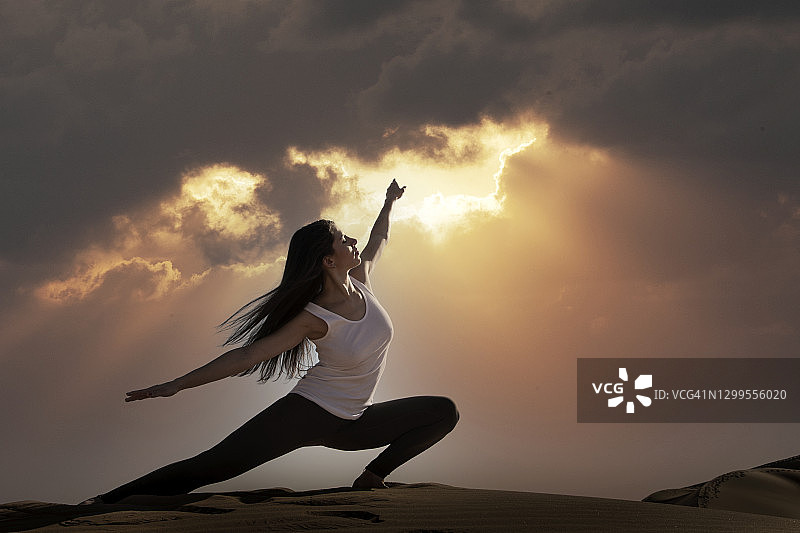 一个女人在日出时练习瑜伽图片素材