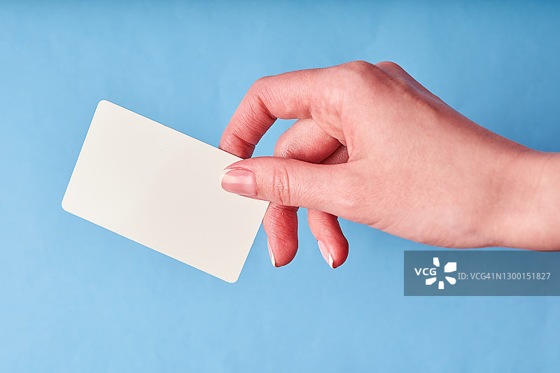 一个女人的手里拿着一张白色的塑料卡片。手持孤立卡片图片素材