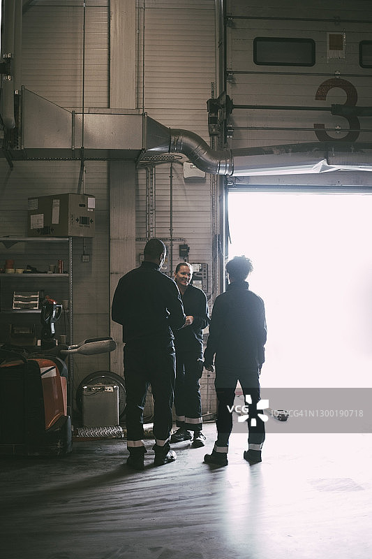 男女同事站在仓库入口时进行规划图片素材