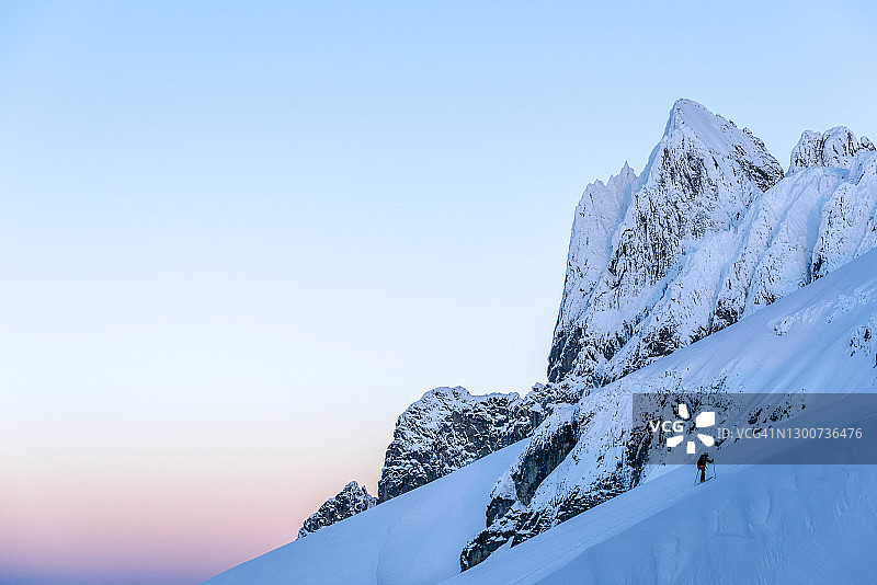 滑雪登山运动员爬高山坡，山下有山图片素材