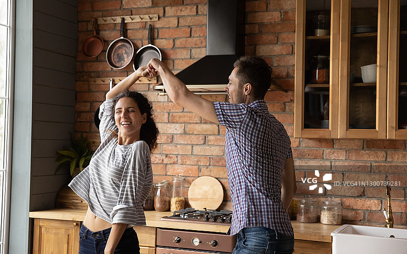 喜出望外的千禧夫妇在新家庭厨房跳舞图片素材