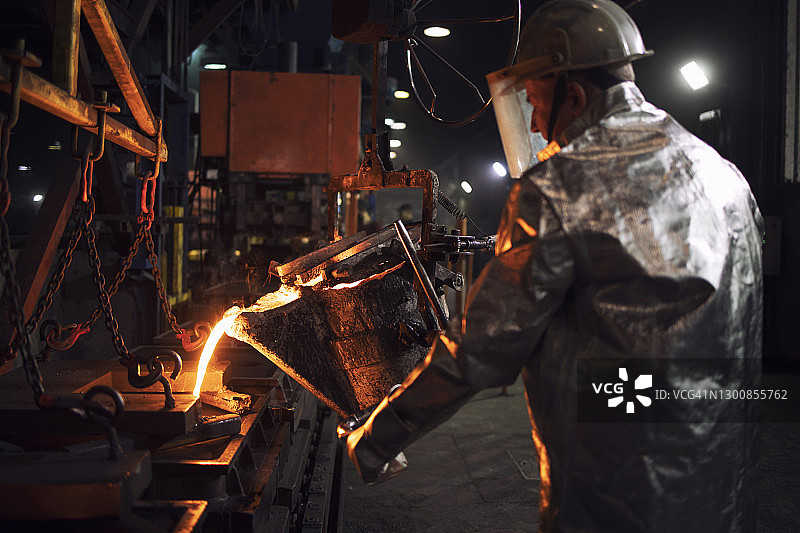 在铸造厂浇注热铁。工业用钢材生产和铸造。图片素材