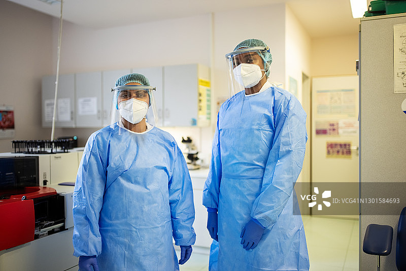 穿着个人防护服的科学家们一起站在实验室里图片素材