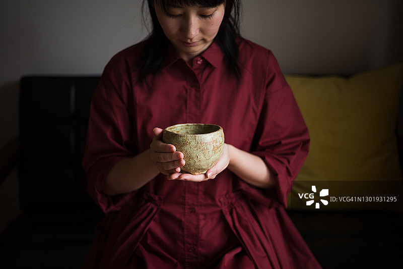 亚洲妇女在家里享受茶道图片素材