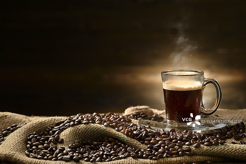 在旧的木制背景上，用粗麻袋装上烟和咖啡豆，一杯一杯的咖啡图片素材
