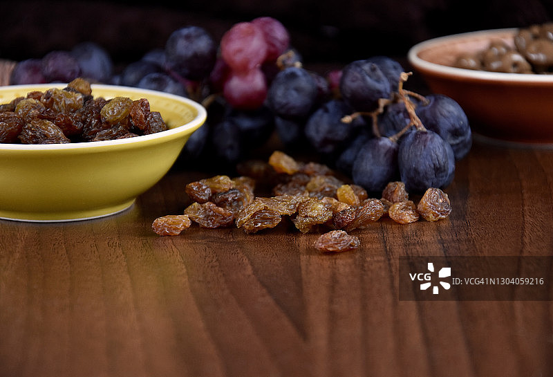干葡萄干与一串葡萄在木背景库存图像图片素材