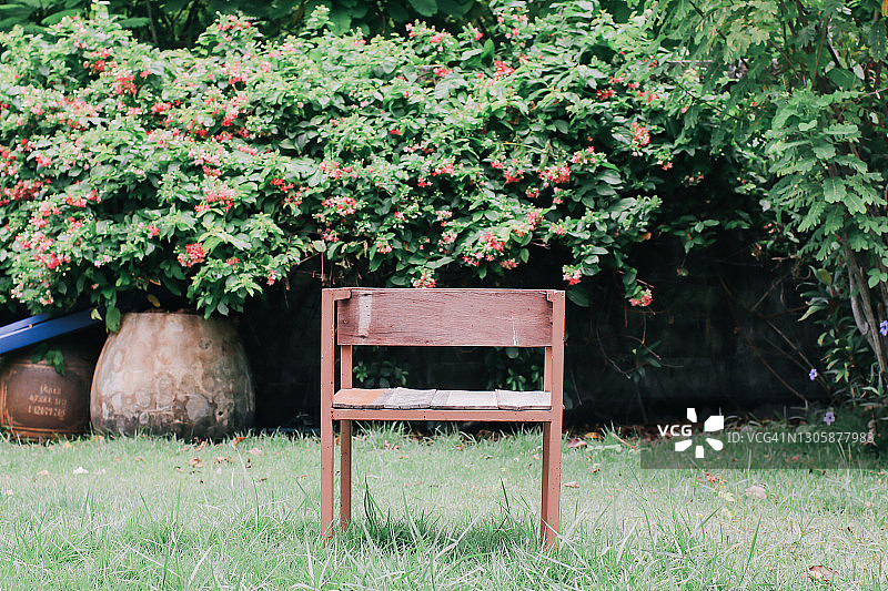 古色古香的木椅在夏日的绿色花园里。为背景。图片素材