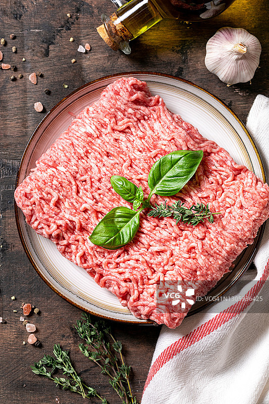 肉。新鲜的生肉末放在一个盘子和木制的背景图片素材