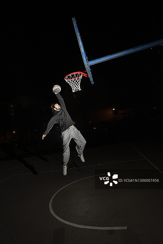 年轻人在晚上打篮球图片素材