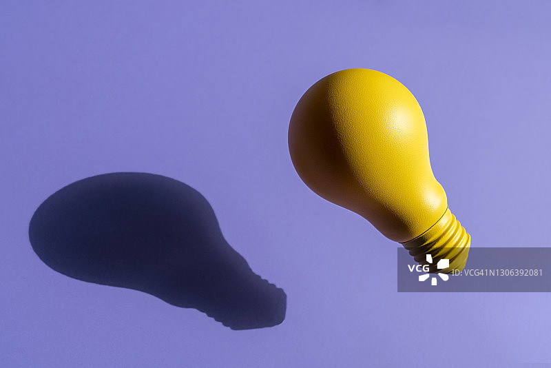 黄色白炽灯灯泡在紫色的背景图片素材