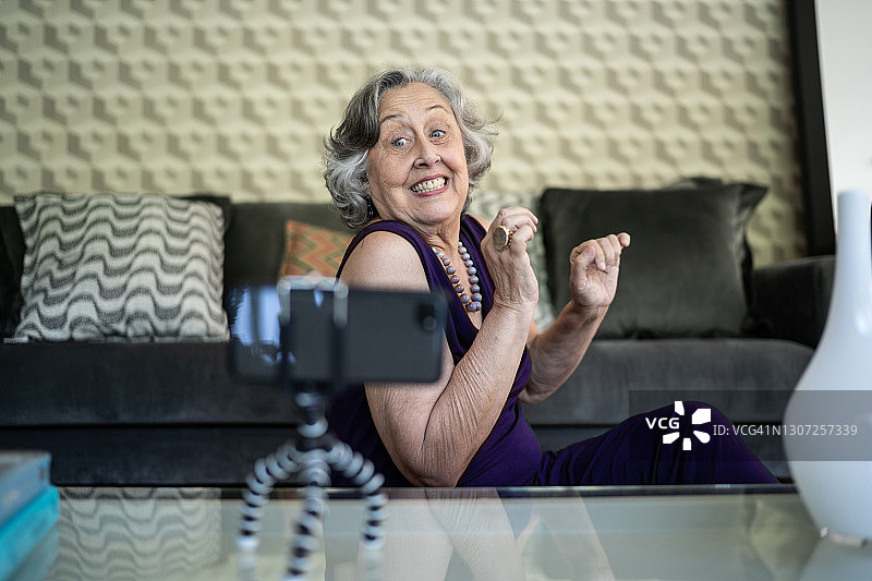 快乐的老女人在家用智能手机打视频电话图片素材