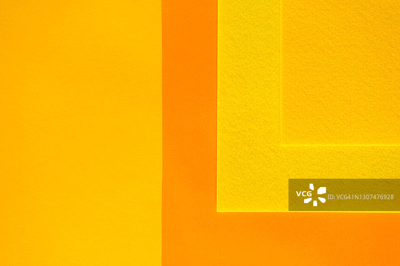 背景由几层纸制成，这些纸的颜色是今年最流行的:明亮的黄色和橙色。平躺风格图片素材