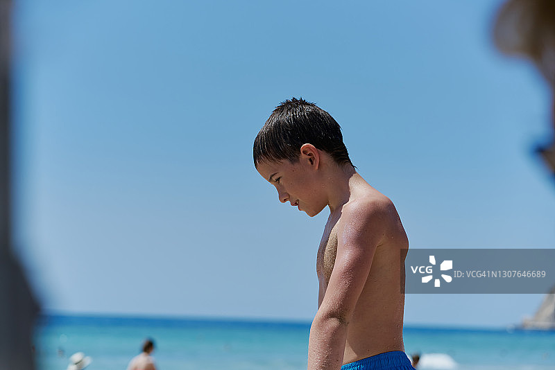 小男孩在海滩上享受阳光明媚的一天。图片素材
