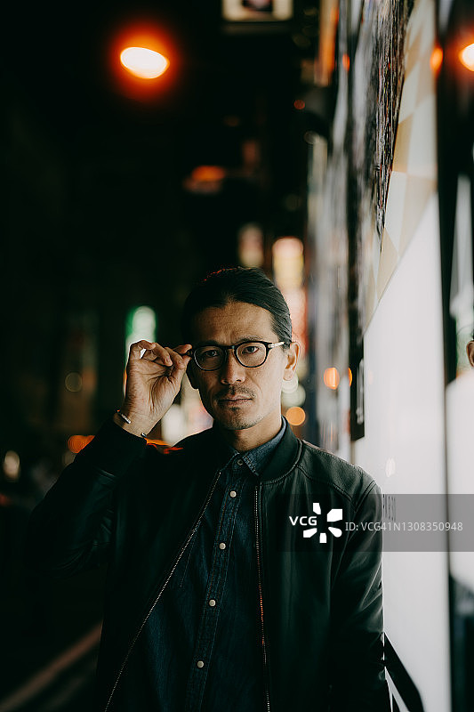 东京，一名戴眼镜的日本男子在夜间观看摄像机图片素材