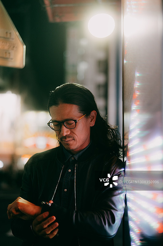 在东京，一个留着长发，戴着眼镜的日本男人图片素材