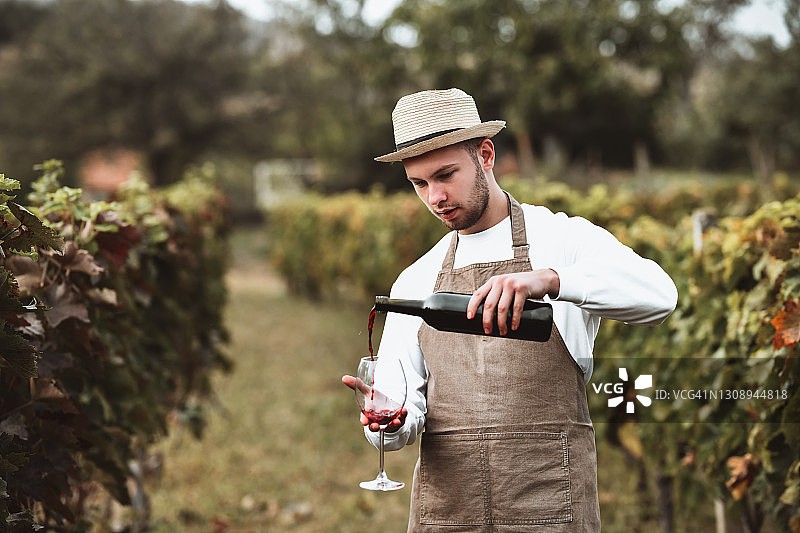 酿酒师和他酿造的血红色葡萄酒图片素材