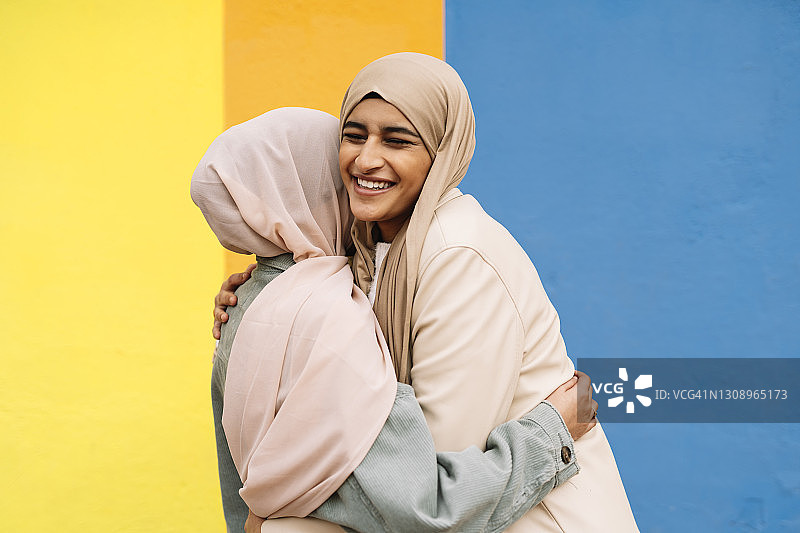 两个阿拉伯女性朋友微笑着在户外拥抱。图片素材