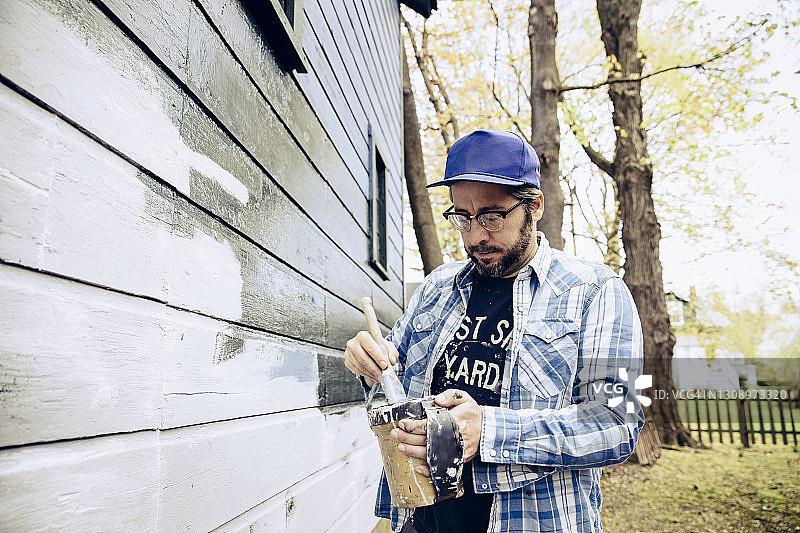 男人在粉刷房子的一边图片素材