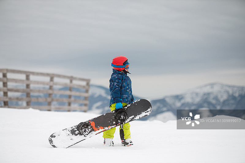 一个带着滑雪板的男孩图片素材