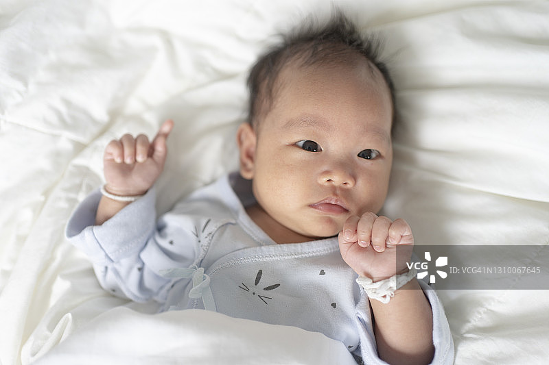 肖像面部表情topview亚洲新生儿在舒适的床上图片素材