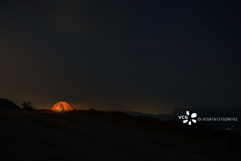 山顶上黄色的帐篷在夜晚点亮图片素材