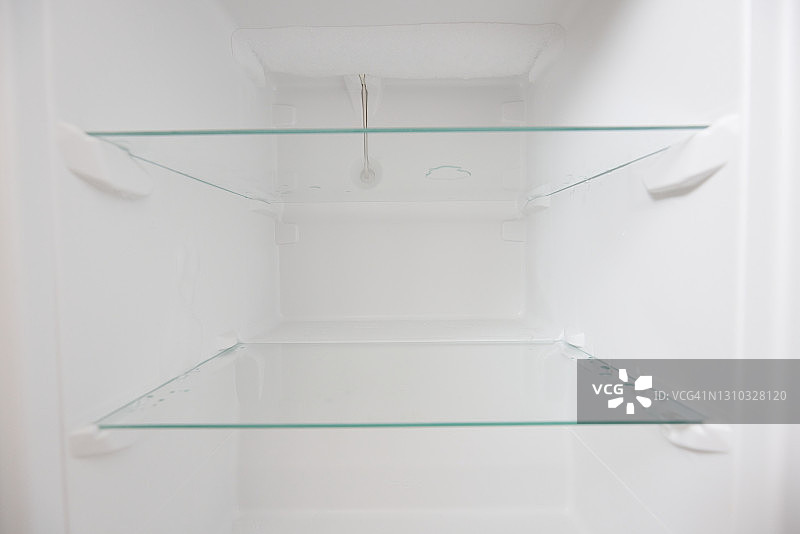 一个空的冰箱。在一个空的，干净的冰箱内，解冻后的冰箱隔间图片素材