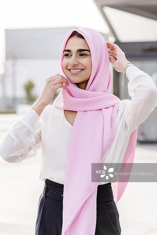 年轻的穆斯林女孩微笑着戴上头巾图片素材