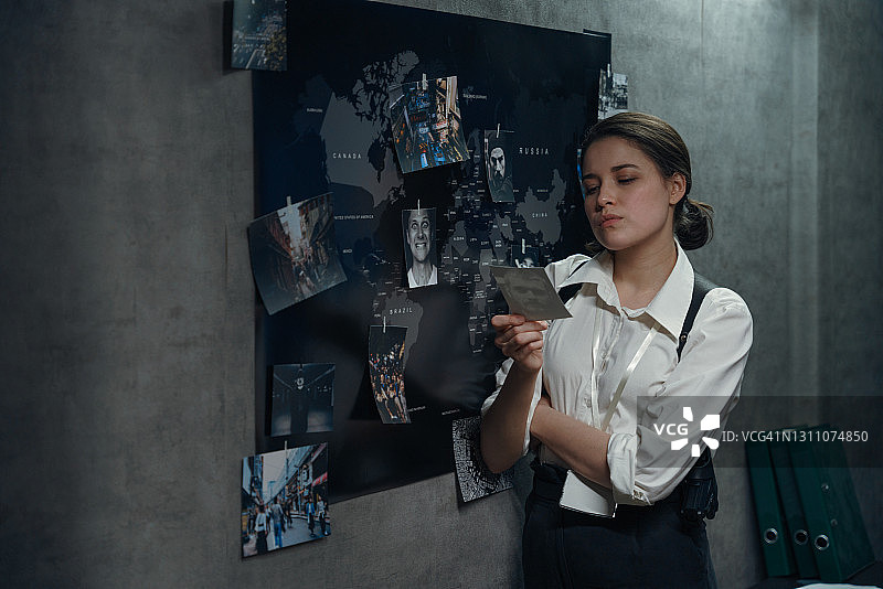 一个女人站在世界地图旁边带着徽章和手枪皮套图片素材