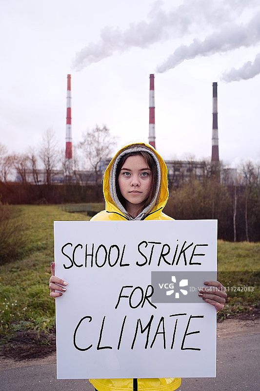 一个少女拿着一张关于气候变化的海报图片素材