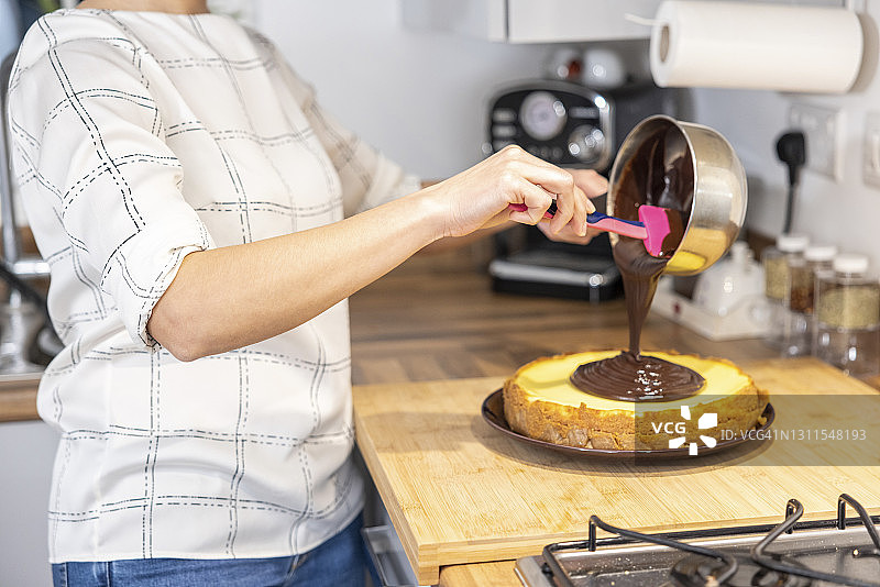 女人在烤蛋糕，把巧克力撒在上面图片素材