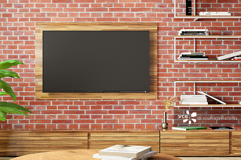 空白电视屏幕模拟在现代客厅的红砖墙上。图片素材