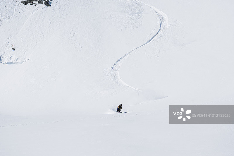 滑雪者从海岸山脉被雪覆盖的山上下来图片素材