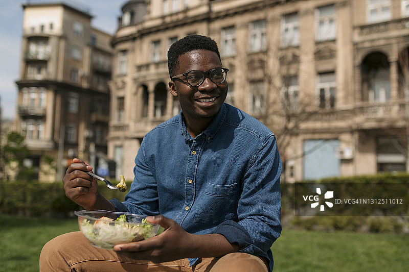 英俊的非裔美国人在公园吃午餐图片素材