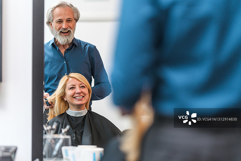 女顾客和男理发师在理发时大笑图片素材
