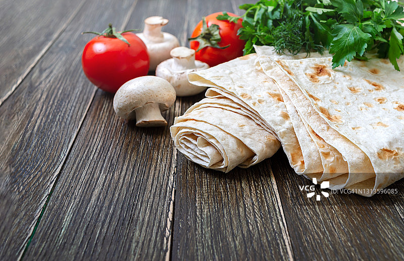 美味、丰盛、健康的亚美尼亚和土耳其无酵扁面包。薄荷叶与新鲜蔬菜的木制背景。复制spase图片素材