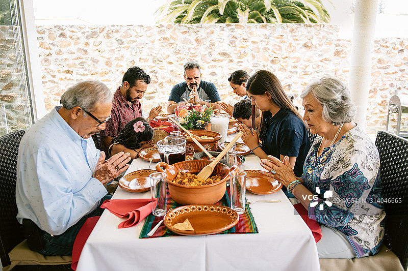 几代同堂的一家人在晚餐前祷告图片素材