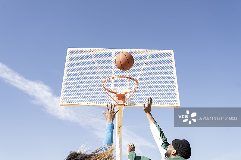 男女朋友在阳光明媚的日子里打篮球图片素材