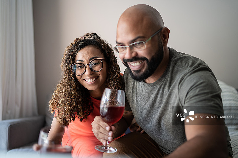 一对夫妇在虚拟的欢乐时光里喝葡萄酒图片素材