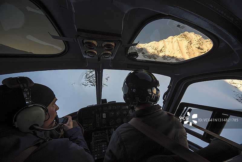滑雪者乘坐直升机飞越雪山图片素材
