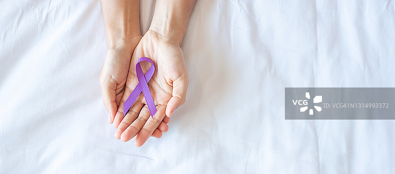 胰腺癌，世界阿尔茨海默病，癫痫，狼疮和家庭暴力日宣传月，妇女举着紫色丝带支持人们生活。医疗保健和世界癌症日概念图片素材