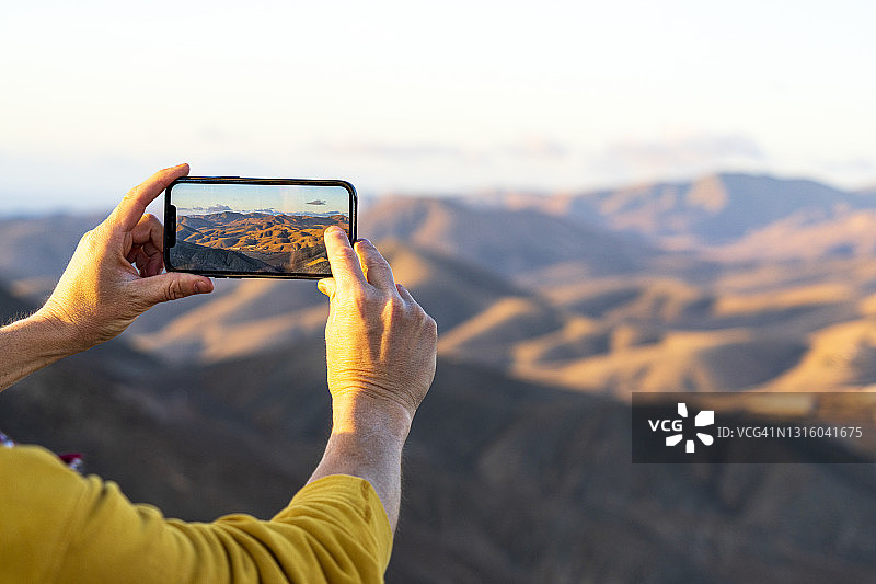 用智能手机拍摄沙漠的人的个人视角，Fuerteventura图片素材