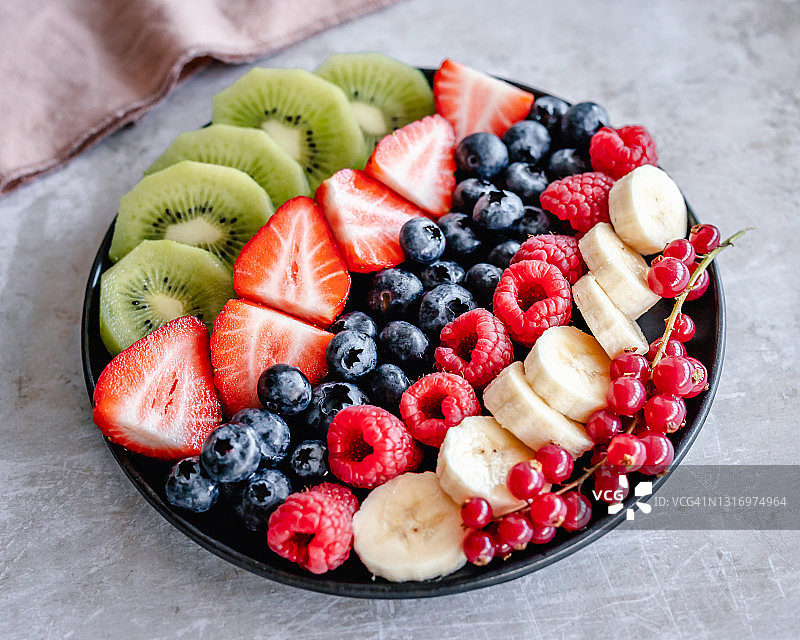 新鲜水果拼盘草莓，覆盆子，香蕉，蓝莓，猕猴桃和红醋栗图片素材