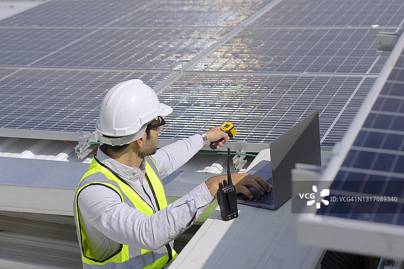 蓝领工人检查太阳能电池板。图片素材
