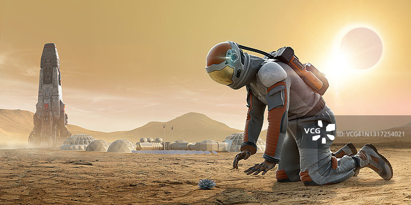 宇航员跪在火星上，盯着一棵生长在布满岩石和灰尘的地面上的植物，背景是宇宙飞船和基地营地图片素材