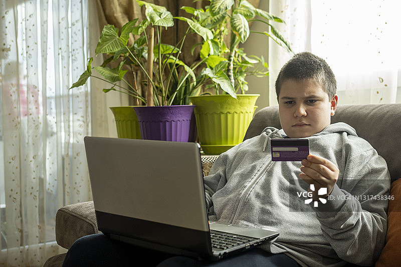 十几岁的男孩用笔记本电脑在网上购物图片素材