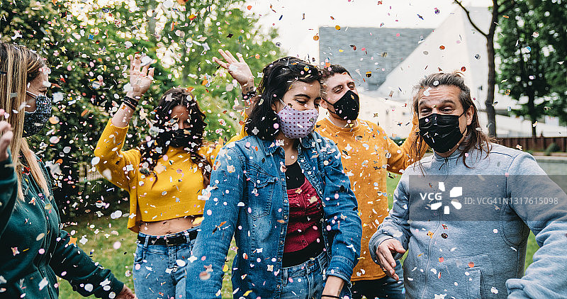一群朋友在户外跳舞，用五彩纸屑一起庆祝图片素材