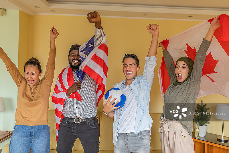 欢乐的多民族美国和加拿大朋友支持国家足球队在国内。图片素材