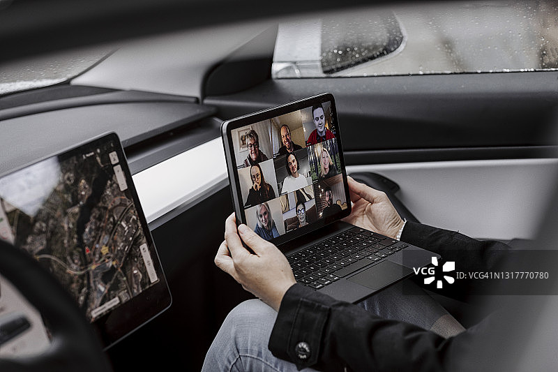 在车里拿着笔记本电脑开视频会议的女人图片素材
