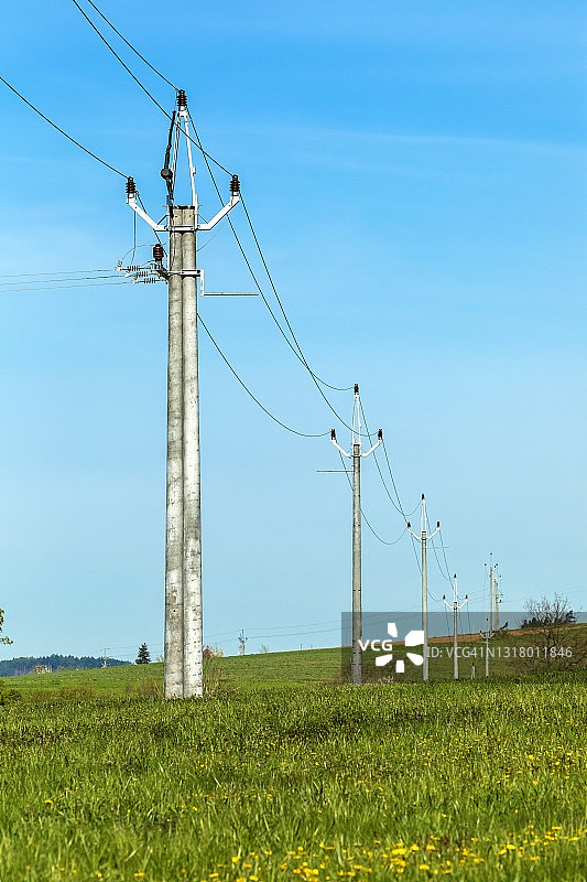 春日的蓝天映衬着乡间的电力线。捷克农村的电力分配。图片素材