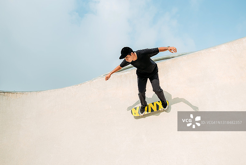 亚洲男性在滑板公园玩滑板图片素材